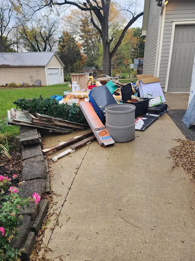 Dumpster being loaded with debris for Estate Cleanout Dumpster Rental in Cedar Lake